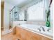 Bright bathroom featuring tiled walls, a shower with glass door, and a garden tub at 724 Laura Jean Ct, Buford, GA 30518