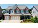 Inviting two-story home with a brick facade, three-car garage, landscaped front yard and charming curb appeal at 724 Laura Jean Ct, Buford, GA 30518