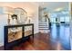 Elegant foyer showcasing dark wood floors, a decorative mirror, and a staircase leading to the upper level at 724 Laura Jean Ct, Buford, GA 30518