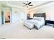 Spacious carpeted main bedroom with tray ceilings and a large upholstered headboard at 724 Laura Jean Ct, Buford, GA 30518