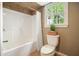 Bright bathroom with a shower-tub combination and window, perfect for relaxation at 1206 Mountainside Nw Trce, Kennesaw, GA 30152