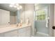 Well-lit bathroom featuring a large mirror, vanity with countertop, and a view of nature through the window at 1206 Mountainside Nw Trce, Kennesaw, GA 30152