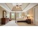 Spacious bedroom featuring a four-poster bed, tray ceiling, ceiling fan, and natural light at 1206 Mountainside Nw Trce, Kennesaw, GA 30152