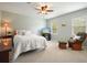 Bright bedroom with neutral decor, two windows, a ceiling fan, and a comfortable sitting area with a rocking chair at 1206 Mountainside Nw Trce, Kennesaw, GA 30152