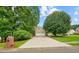 Long driveway leads to a two-car garage with a manicured lawn and mature trees at 1206 Mountainside Nw Trce, Kennesaw, GA 30152