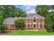 Charming two-story red brick home features black shutters, arched entry, and well-manicured lawn at 1206 Mountainside Nw Trce, Kennesaw, GA 30152