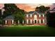 Charming two-story red brick home features black shutters, arched entry, and a well-manicured lawn at sunset at 1206 Mountainside Nw Trce, Kennesaw, GA 30152