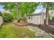 Backyard shed with neutral paint and white trim is nestled among the trees and mossy ground at 1206 Mountainside Nw Trce, Kennesaw, GA 30152