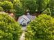 Aerial view of home surrounded by mature trees, featuring a light gray exterior and dark roof at 1607 Boulder Walk Se Dr, Atlanta, GA 30316