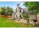 Rear exterior view of the home showing a patio, gravel area, garden beds, fenced yard, and lush greenery at 1607 Boulder Walk Se Dr, Atlanta, GA 30316