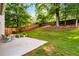 Spacious backyard featuring a large concrete patio area perfect for entertaining, along with mature trees and shrubbery at 1607 Boulder Walk Se Dr, Atlanta, GA 30316