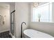 Bright bathroom featuring a standalone tub with floor mounted faucet and a black framed shower at 1607 Boulder Walk Se Dr, Atlanta, GA 30316