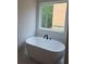 Modern soaking tub paired with dark hardware sits beneath a bright window offering exterior views at 195 Silvercrest Dr, Acworth, GA 30101
