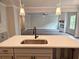 Bright, open-concept kitchen island with sink and view of fireplace in living room at 195 Silvercrest Dr, Acworth, GA 30101