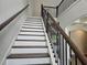 Elegant staircase with hardwood treads, white risers, dark wood banister, and black iron spindles at 195 Silvercrest Dr, Acworth, GA 30101