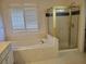 Bathroom features a tub, shower with gold frame and blinds on the window at 4217 Mill Grove Sw Ln, Smyrna, GA 30082