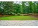 The property boasts a beautifully manicured backyard featuring lush greenery at 8895 Club River Dr, Roswell, GA 30076