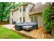Exterior backyard showcasing a deck and patio with outdoor seating, surrounded by green grass and trees at 8895 Club River Dr, Roswell, GA 30076