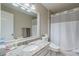 Bright bathroom featuring granite counters, a large mirror, and shower-tub combination with gray shower curtain at 8895 Club River Dr, Roswell, GA 30076