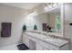 Bright bathroom offering double sinks, ample lighting, and granite counters at 8895 Club River Dr, Roswell, GA 30076