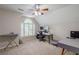 Cozy bedroom with an arched window, ceiling fan, neutral carpet, and desk in a converted attic space at 8895 Club River Dr, Roswell, GA 30076
