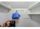Walk-in closet with shelving, clothes rod, and a blue tote bag hanging on hooks at 8895 Club River Dr, Roswell, GA 30076