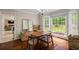 Cozy dining room features hardwood floors, natural light from windows, and a view into the living room at 8895 Club River Dr, Roswell, GA 30076