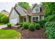 Charming home exterior features well-maintained landscaping and a two-car garage at 8895 Club River Dr, Roswell, GA 30076