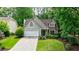 Charming home with a well-manicured lawn, lush landscaping, and a two-car garage at 8895 Club River Dr, Roswell, GA 30076
