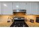 Close-up of kitchen with granite countertops, stainless steel appliances, and gas range at 8895 Club River Dr, Roswell, GA 30076