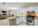 Open kitchen with stainless steel appliances, granite counters, and view of living room with fireplace at 8895 Club River Dr, Roswell, GA 30076