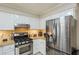 Kitchen showcasing stainless steel appliances, white cabinets, and under-cabinet lighting at 8895 Club River Dr, Roswell, GA 30076