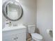 Clean powder room offering a decorative mirror, vanity, and neutral colored walls at 8895 Club River Dr, Roswell, GA 30076