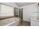 Bathroom featuring a soaking tub, a glass-enclosed shower, and a vanity at 136 Parkstone Way, Marietta, GA 30066