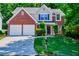 Charming two-story brick home with manicured lawn and attached two-car garage at 136 Parkstone Way, Marietta, GA 30066