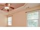 Cozy bedroom with a ceiling fan, tray ceiling, and bright windows at 136 Parkstone Way, Marietta, GA 30066