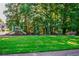 Community playground with swings and slide set amongst lush green grass and mature trees at 136 Parkstone Way, Marietta, GA 30066