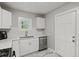 Bright kitchen space showcasing white cabinets, stainless steel dishwasher, and marble tile floors at 5074 Park Ave, Forest Park, GA 30297