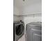 Laundry room with modern, grey, front-loading washer and dryer and marble floors at 5074 Park Ave, Forest Park, GA 30297