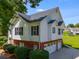 View of the side of the home featuring a brick basement level, white siding, dark shutters, and a three-car garage at 5077 Fieldview Dr, Douglasville, GA 30135