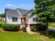 Charming two-story home features a manicured lawn, complemented by a white exterior, and a welcoming front porch with a brick accent at 5077 Fieldview Dr, Douglasville, GA 30135