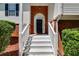 Covered entryway with white stairs, brick accents, complemented by manicured landscaping, and a secure black front door at 5077 Fieldview Dr, Douglasville, GA 30135