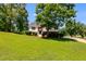 Traditional style home with manicured green lawn, mature trees, and welcoming front entrance with charming brick details at 5077 Fieldview Dr, Douglasville, GA 30135