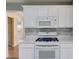 Well-equipped kitchen featuring white cabinetry, modern appliances, stylish backsplash, and marble countertops at 5077 Fieldview Dr, Douglasville, GA 30135