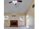 Living room features a brick fireplace, plush carpeting, natural light, and a vaulted ceiling with a ceiling fan at 5077 Fieldview Dr, Douglasville, GA 30135