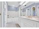 Bright bathroom featuring bathtub, marble counter top, blue walls and white cabinets at 740 Skyline Dr, Covington, GA 30014