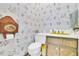 Unique powder room featuring floral wallpaper and a yellow sink and toilet accessories at 740 Skyline Dr, Covington, GA 30014