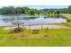 Beautiful lakefront beach area with a picnic table under an umbrella and a swing for relaxing at 740 Skyline Dr, Covington, GA 30014