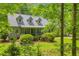 Traditional home exterior with dormer windows, covered porch, and lush green landscaping in a wooded setting at 740 Skyline Dr, Covington, GA 30014