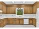 Well-lit kitchen features wooden cabinets, white countertops, and a view of the wooded outdoors at 740 Skyline Dr, Covington, GA 30014